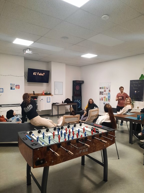 © Ein Jugendzentrum mit Tischfußballtisch und Menschen im Hintergrund