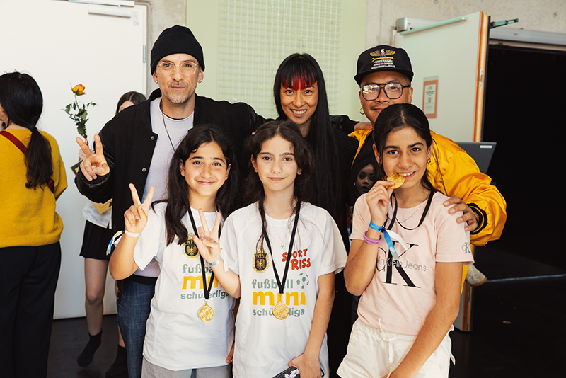 Die Move Your Bones Jury posiert gemeinsam mit einer Tanzgruppe für ein Foto.