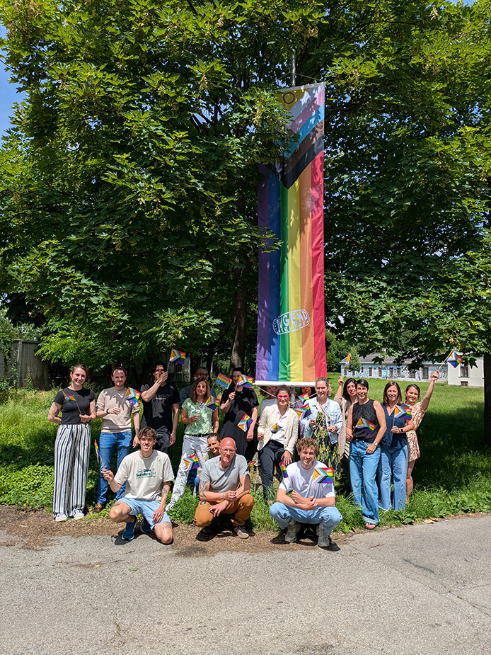 Die Mitarbeiter:innen der zentralen Geschäftsstelle des Verein Wiener Jugendzentren hissen die Pride Fahne.