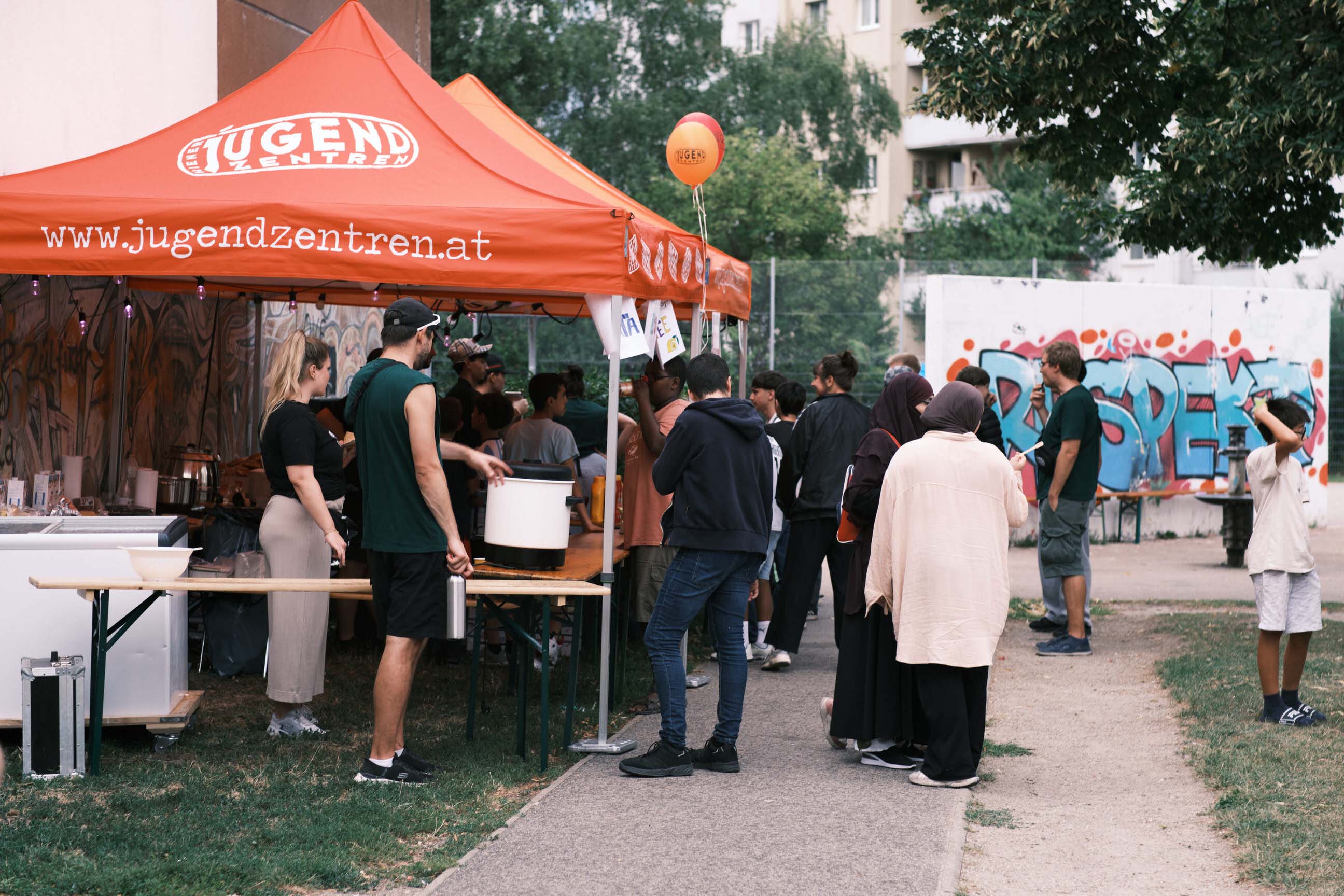 Kinder, Jugendliche und Erwachsene beim Fest vor dem Essens-Zelt.