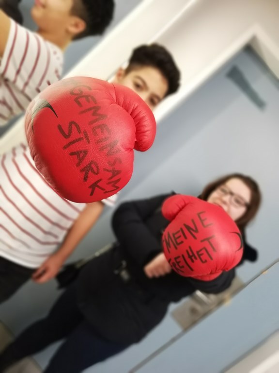 © Verein Wiener Jugendzentren zwei Jugendliche stehen mit roten Boxhandschuhen da, vorauf geschrieben steht: Gemeinsam stark, Freiheit