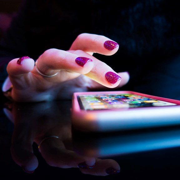 © Rob Hampson / unsplash Eine Hand mit lackierten Fingernägeln tippt auf einem Smartphone