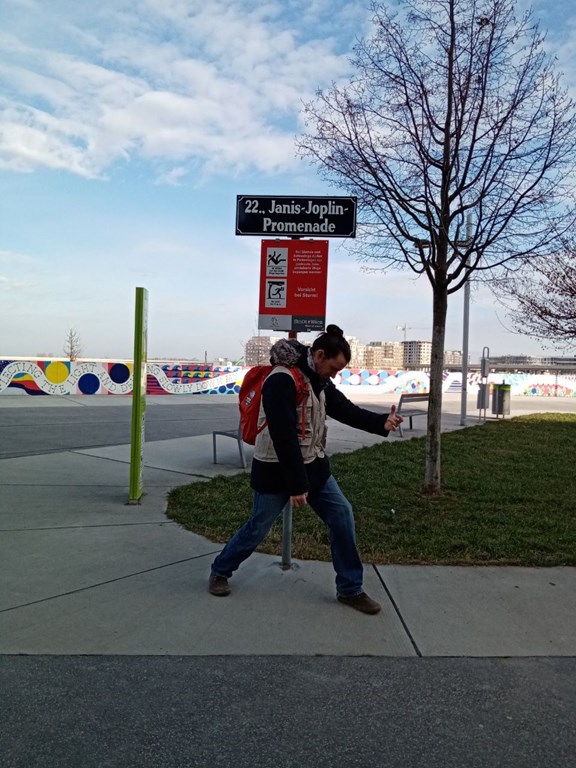 © Verein Wiener Jugendzentren Mitarbeiter vor Straßennamenschild in Janis-Joplin-Promenade