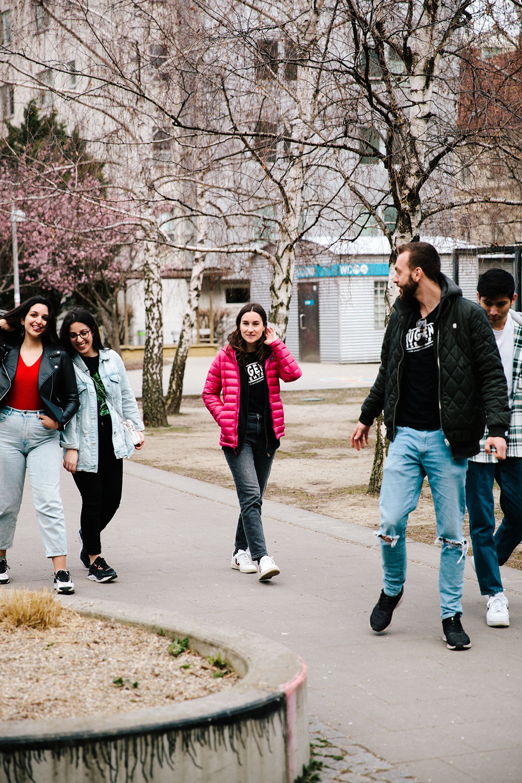 Eine Gruppe von Jugendlichen und Jugendarbeiter:innen läuft durch einen Park. 