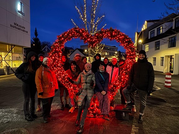 Gruppe von Personen vor einem Herz aus roten LED-Lichtern