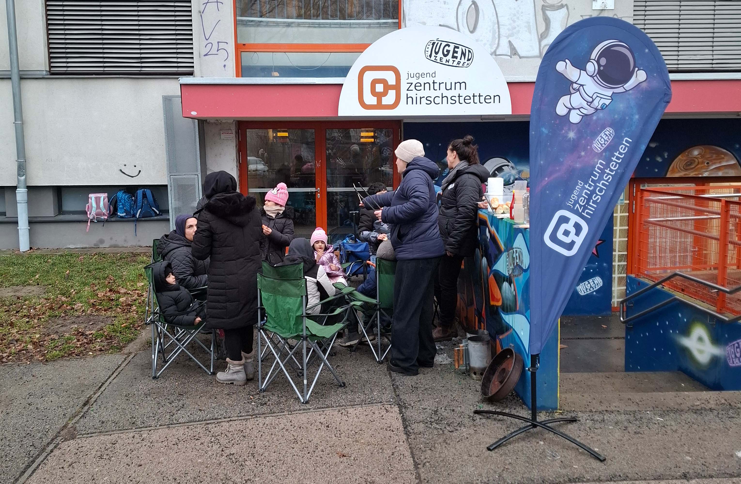 Vor dem Jugendzentrum Hirschstetten chillen Kinder mit ihren Eltern und werden vom Team des Jugendzentrum Hirschstetten informiert.