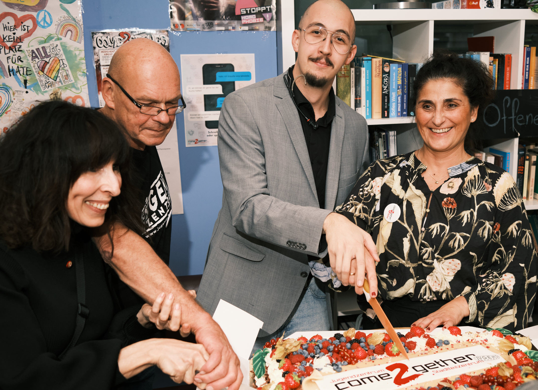 Gemeinderätin Patricia Anderle, come2gether-Leiter „Mozart“, Moderator Marcel und Jugendzentren-Geschäftsführerin Manuela Smertnik beim Anschneiden der Jubiläumstorte des come2gether