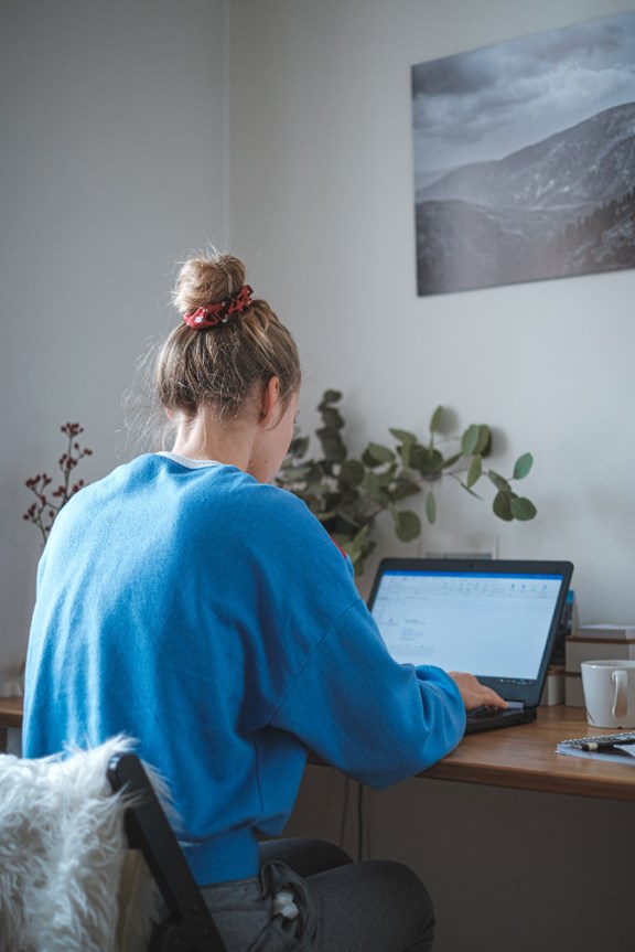 Junge Frau sitzt am Laptop