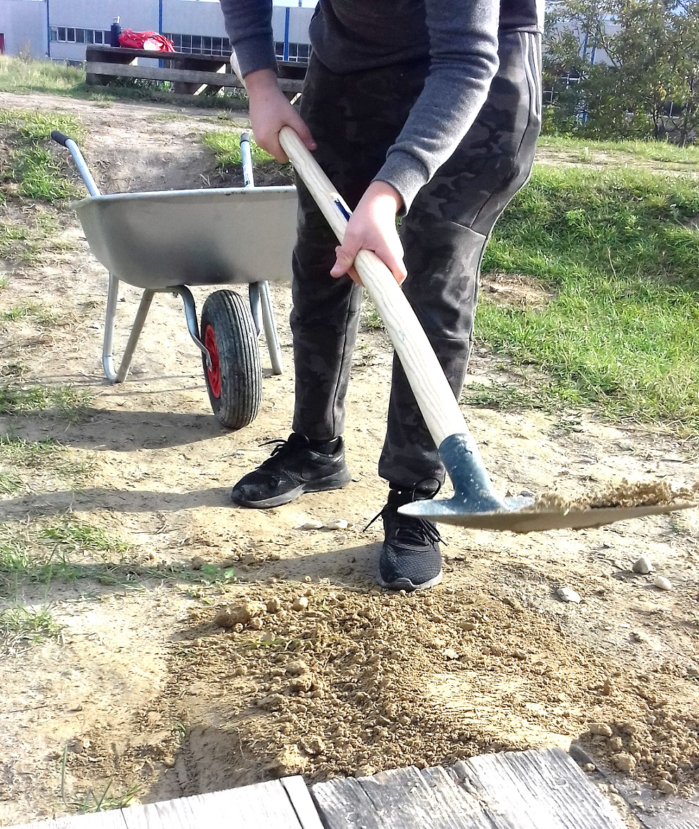 Jugendliche schauffeln an Rampe vom Bikepark