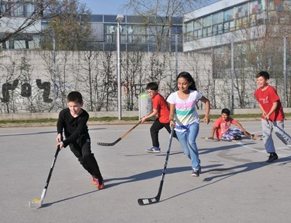 Kinder spielen Hockey im Park