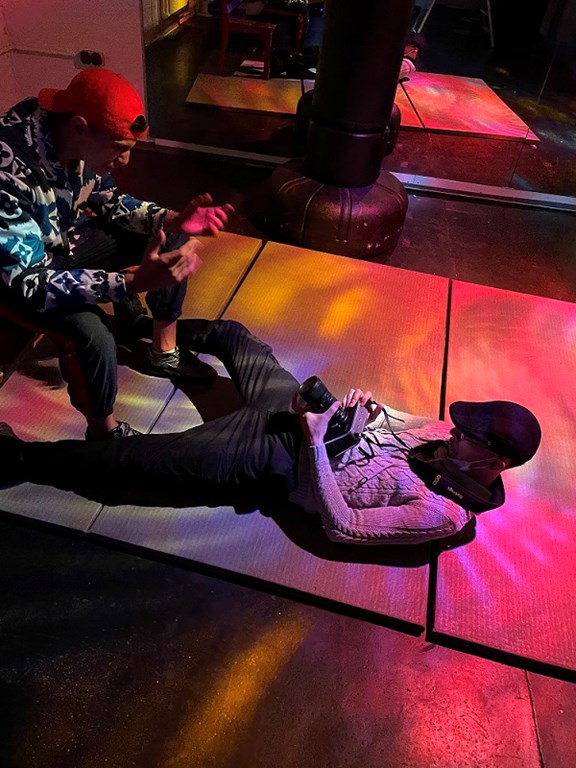 Kameramann liegt am Boden und filmt Rapper Peki